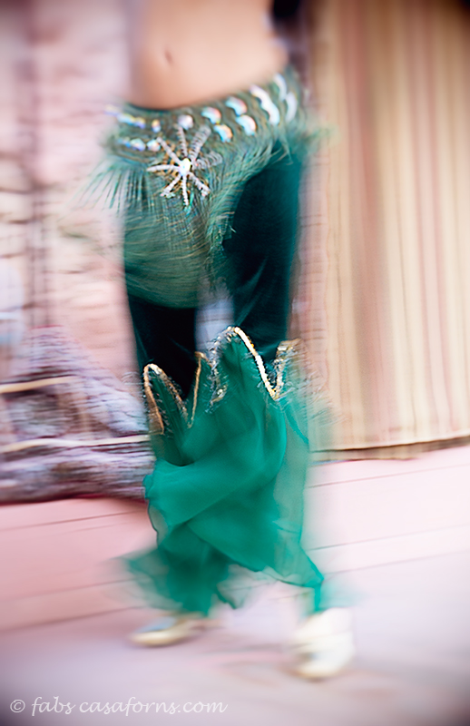 Close up in slow shutter speed to capture the motion of the dance. I didn't go for the face because it would be a distraction.